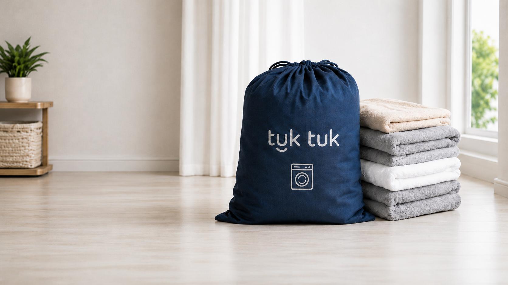 tuk tuk laundry bag beside a stack of clean towels